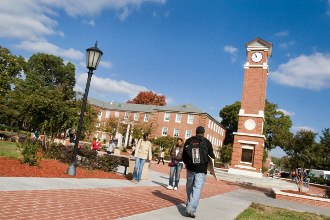 students walking; clock tower; building